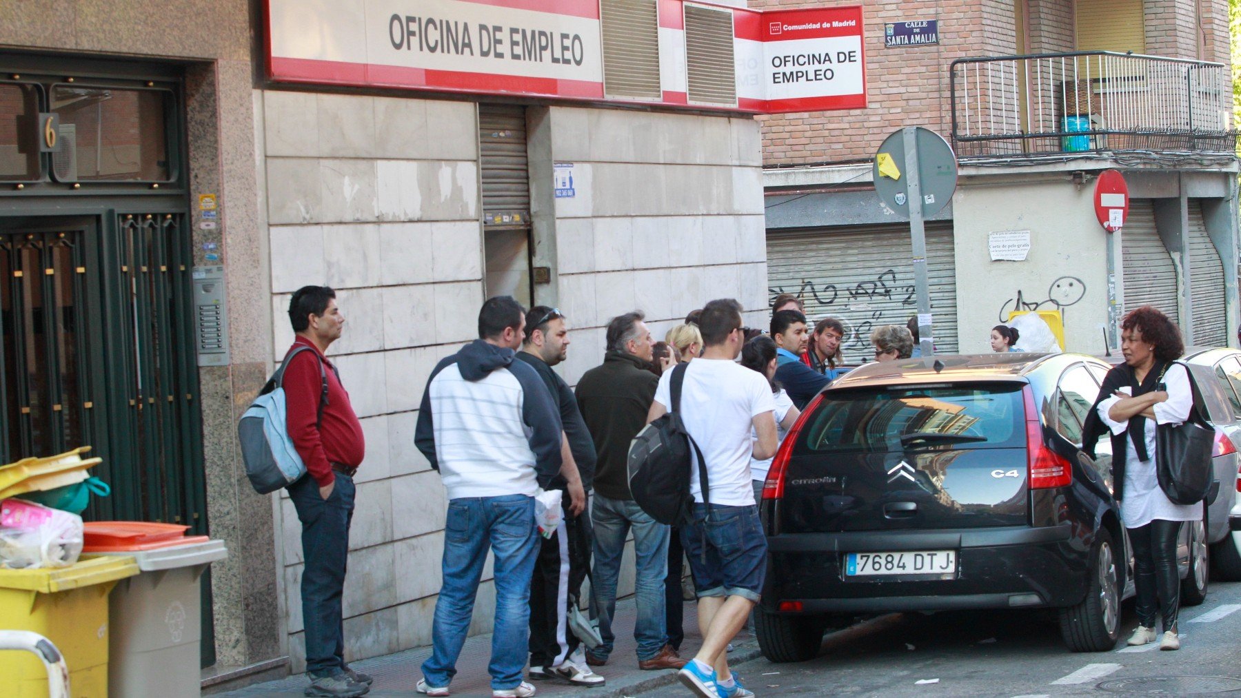 Varias personas delante de una puerta del INEM. (EP)