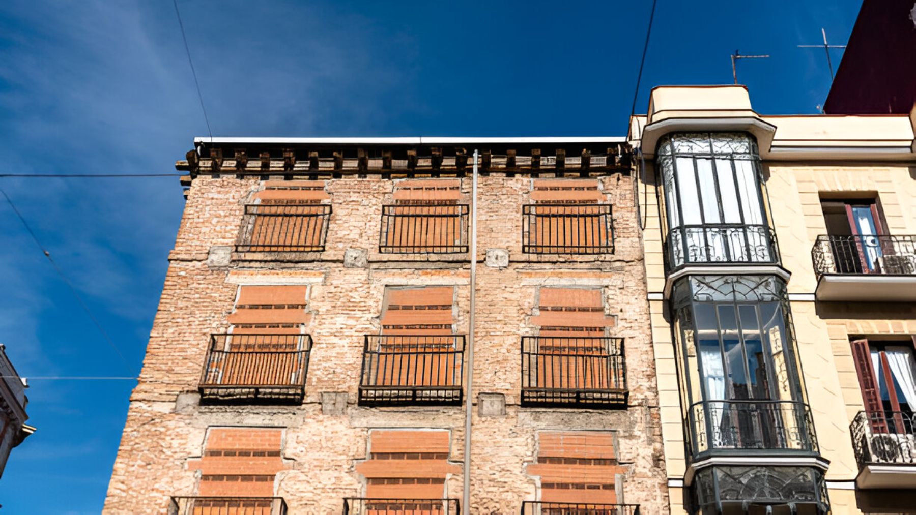 Edificio residencial con ventanas tapiadas para evitar la entrada de okupas.