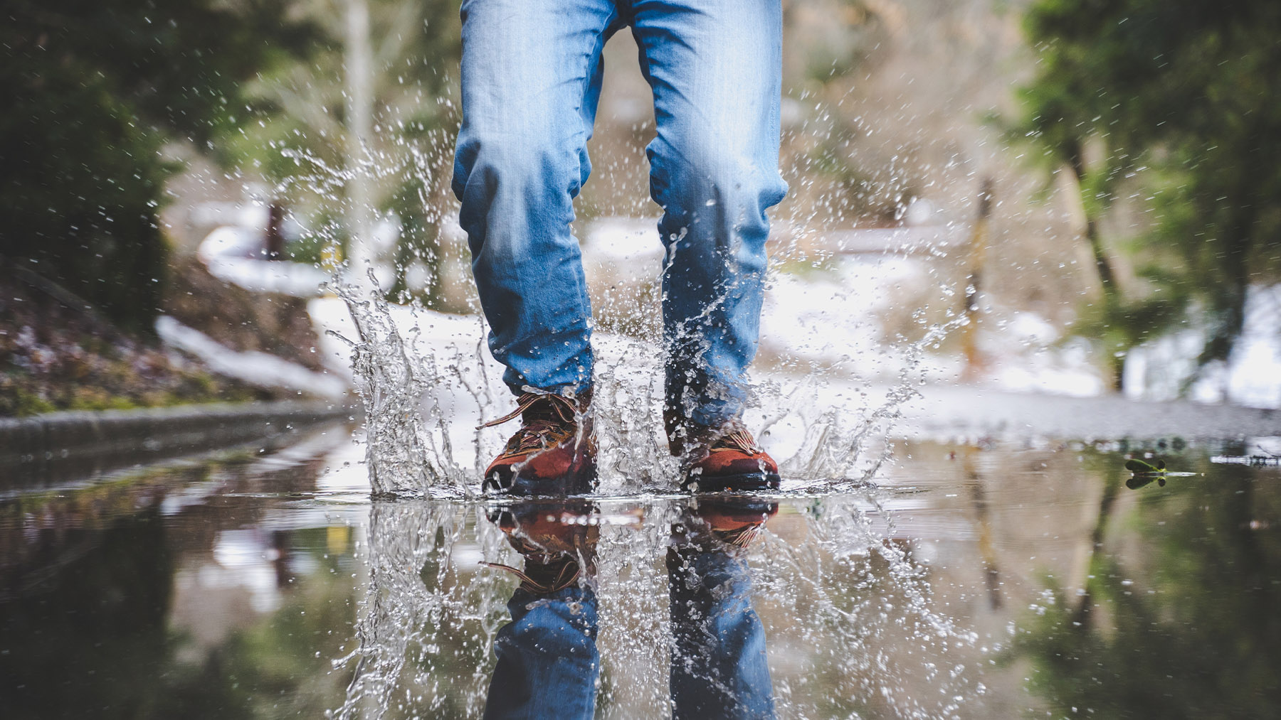 Zapatos mojándose en un charco. Foto: Freepik.