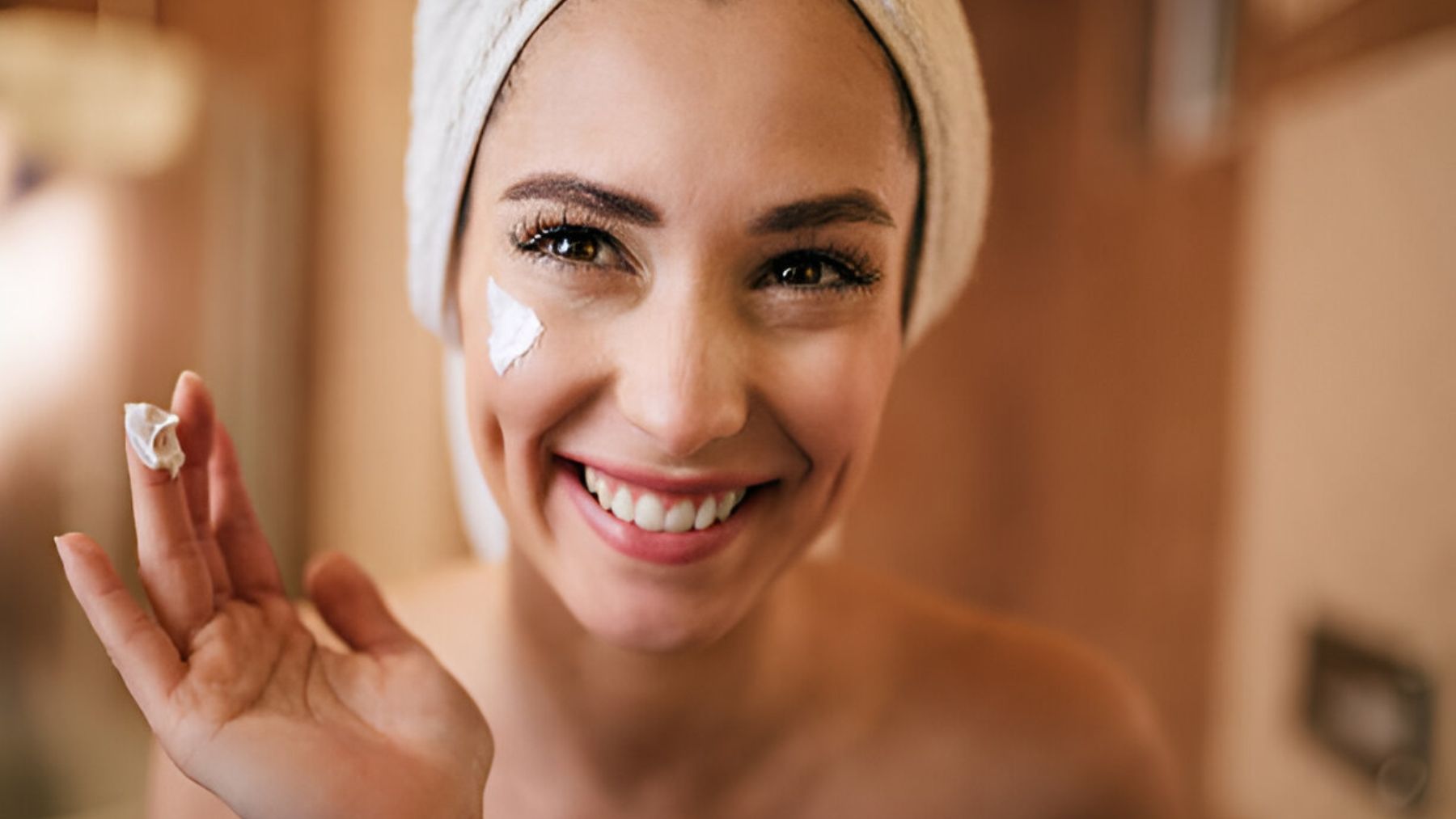 Joven aplicándose crema facial.