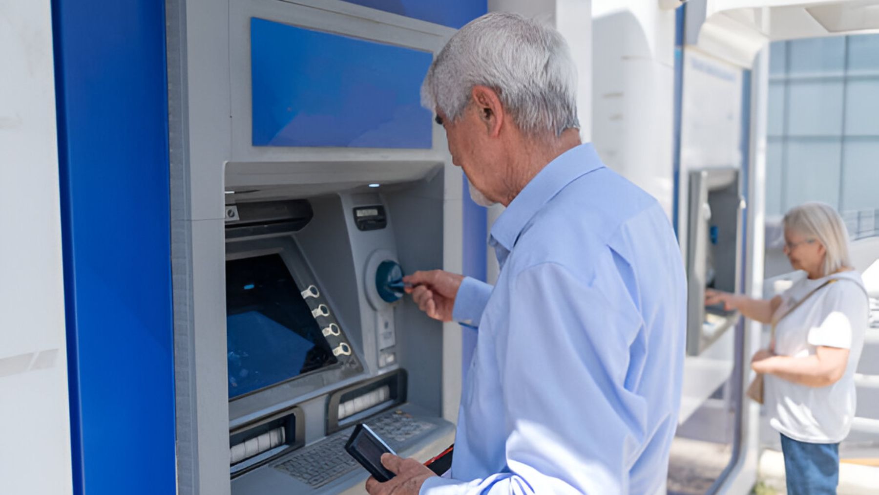 Persona mayor sacando dinero del cajero.