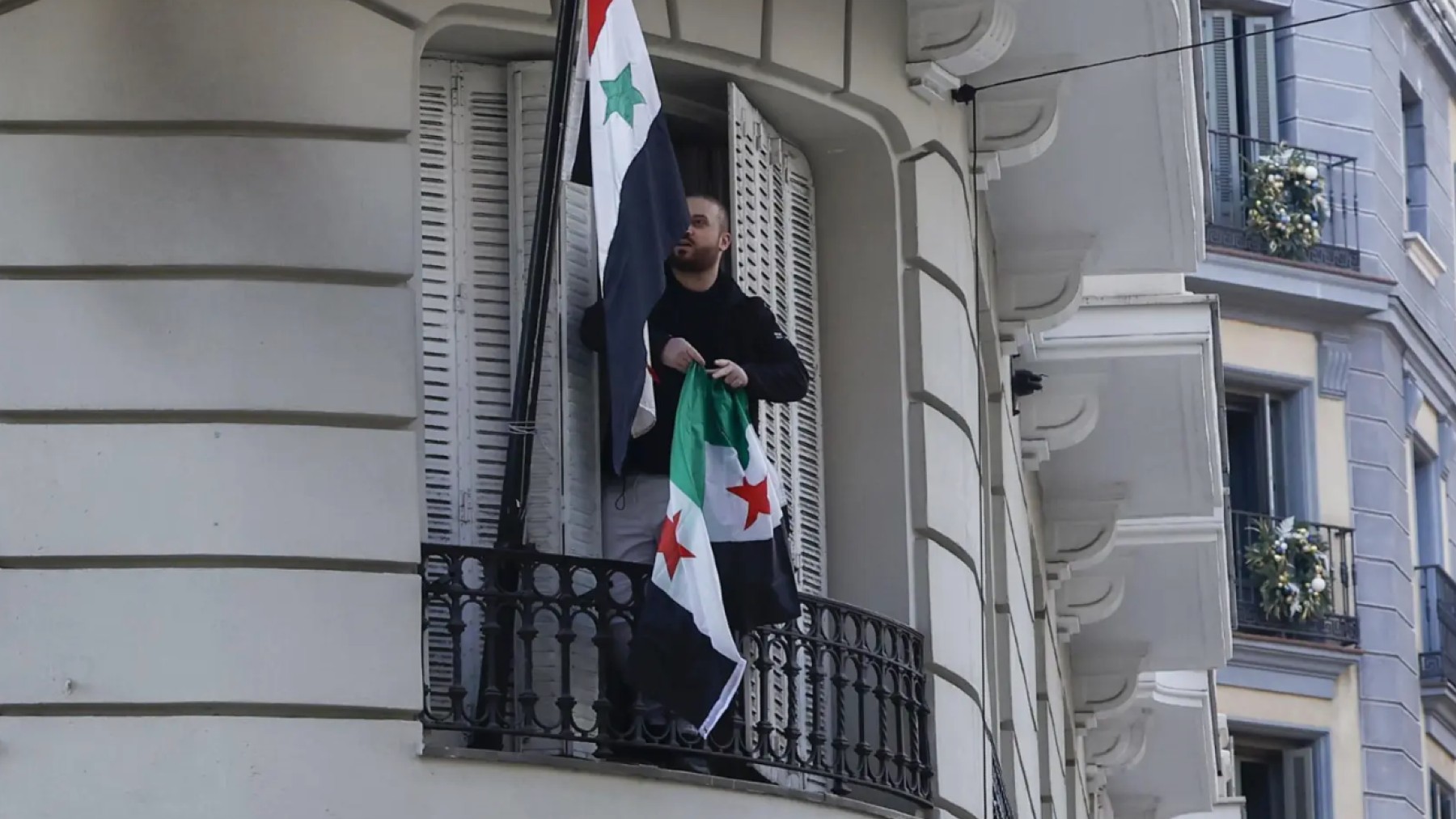 Cambian la bandera siria por la nueva rebelde en la embajada de Siria en Madrid. EFE