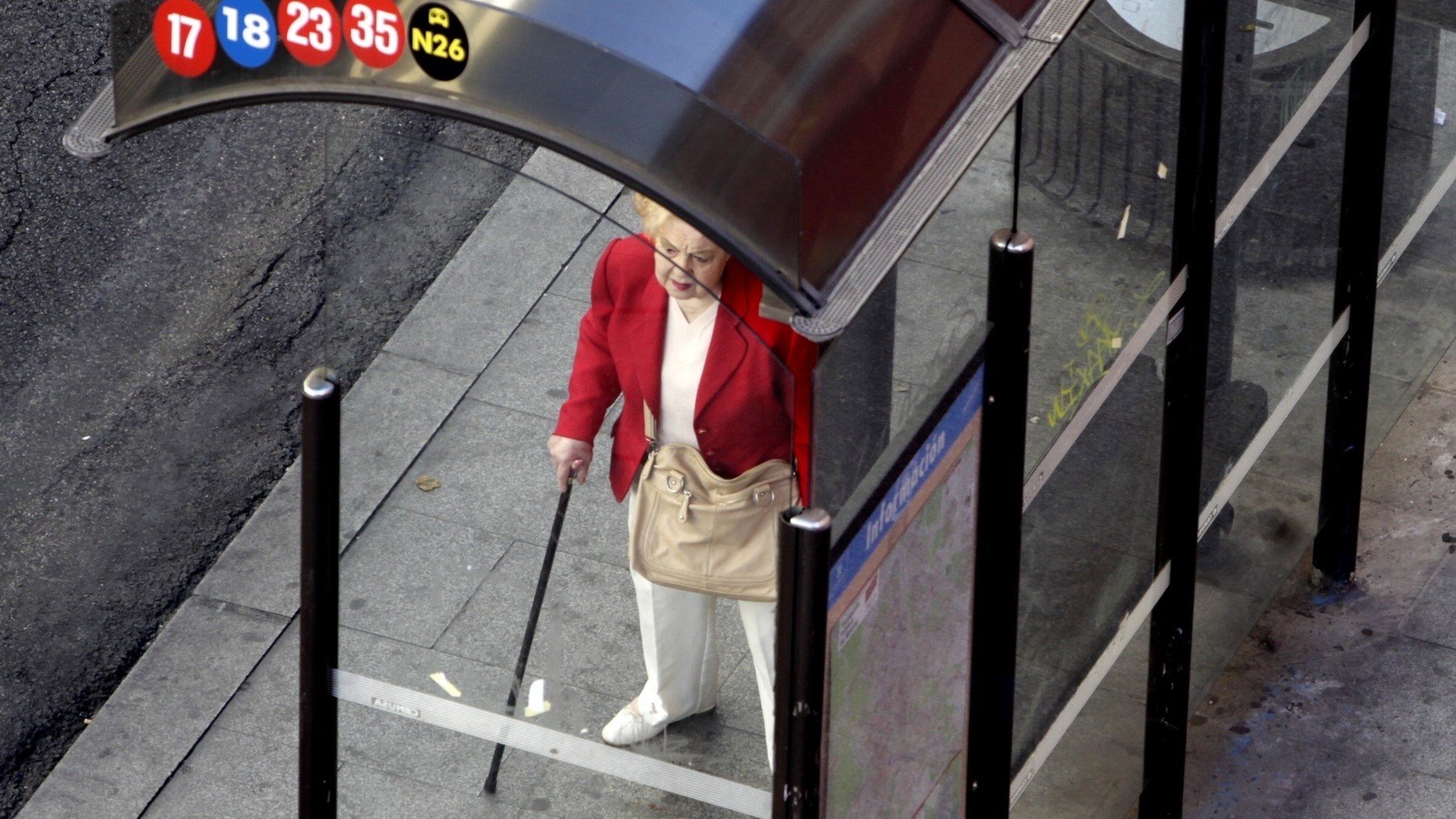 Una mujer mayor en la parada de un autobús en Madrid. (EP)