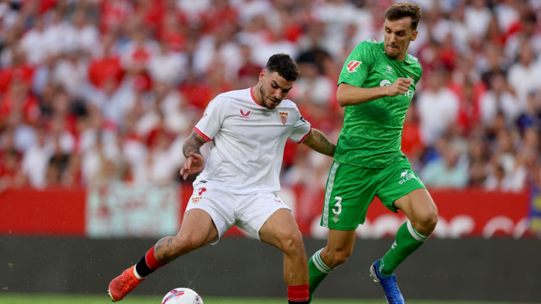 Isaac Romero disputa un balón en presencia de Diego Llorente. (Getty)