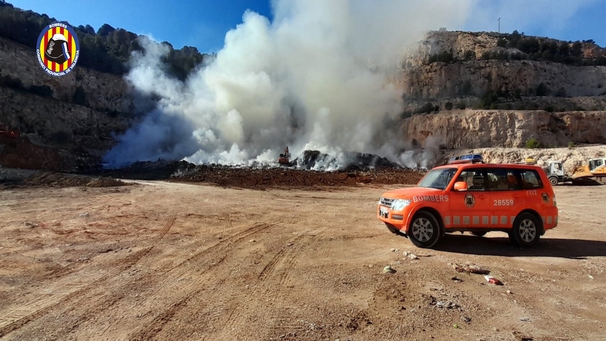 Un vehículo del Consorcio de Bomberos de Valencia ante la nube de humo del incendio.