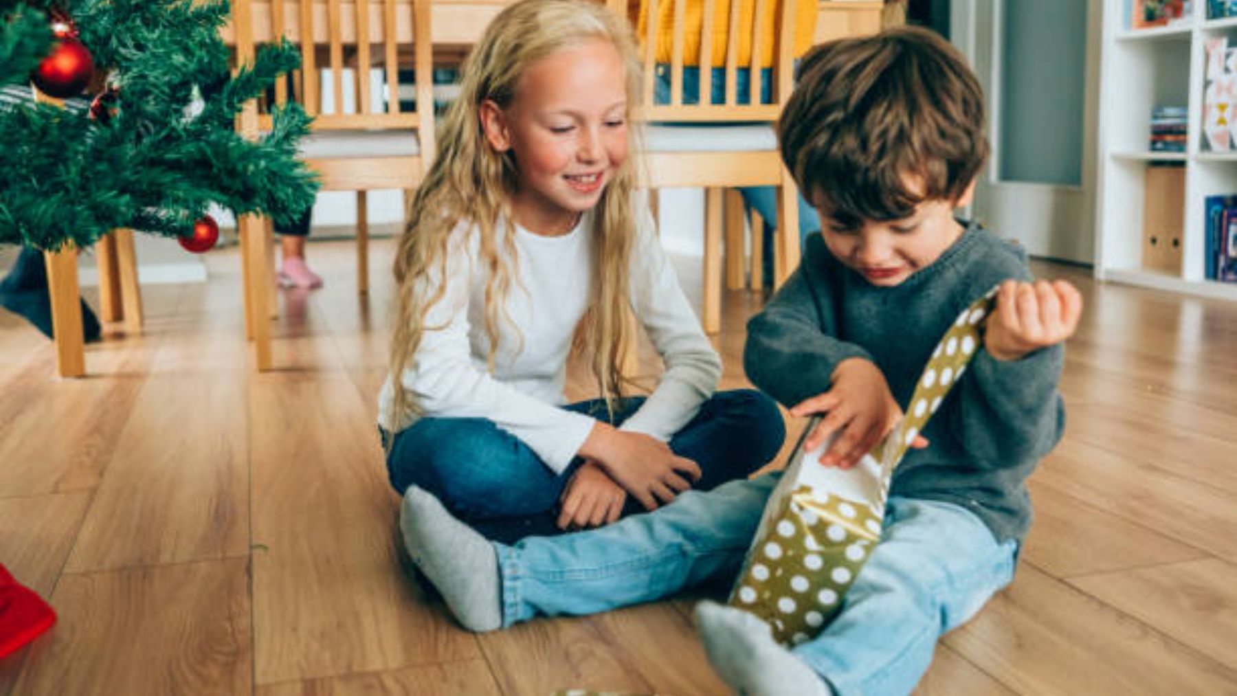 Niños abriendo regalos de Navidad.