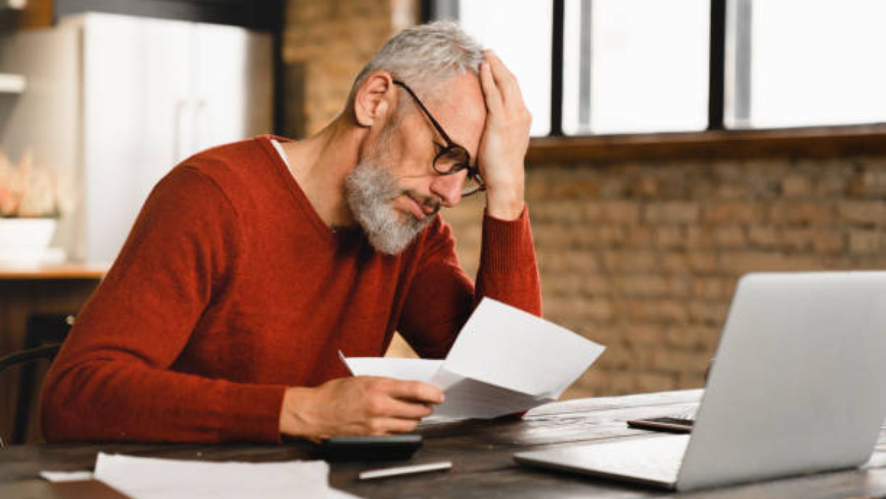 Hombre preocupado leyendo un documento.