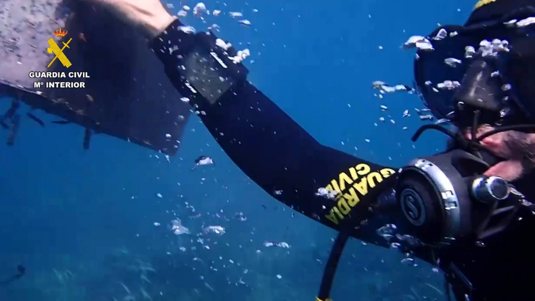 Un agente de los GEAS sacando una batería del fondo del mar en Ibiza.