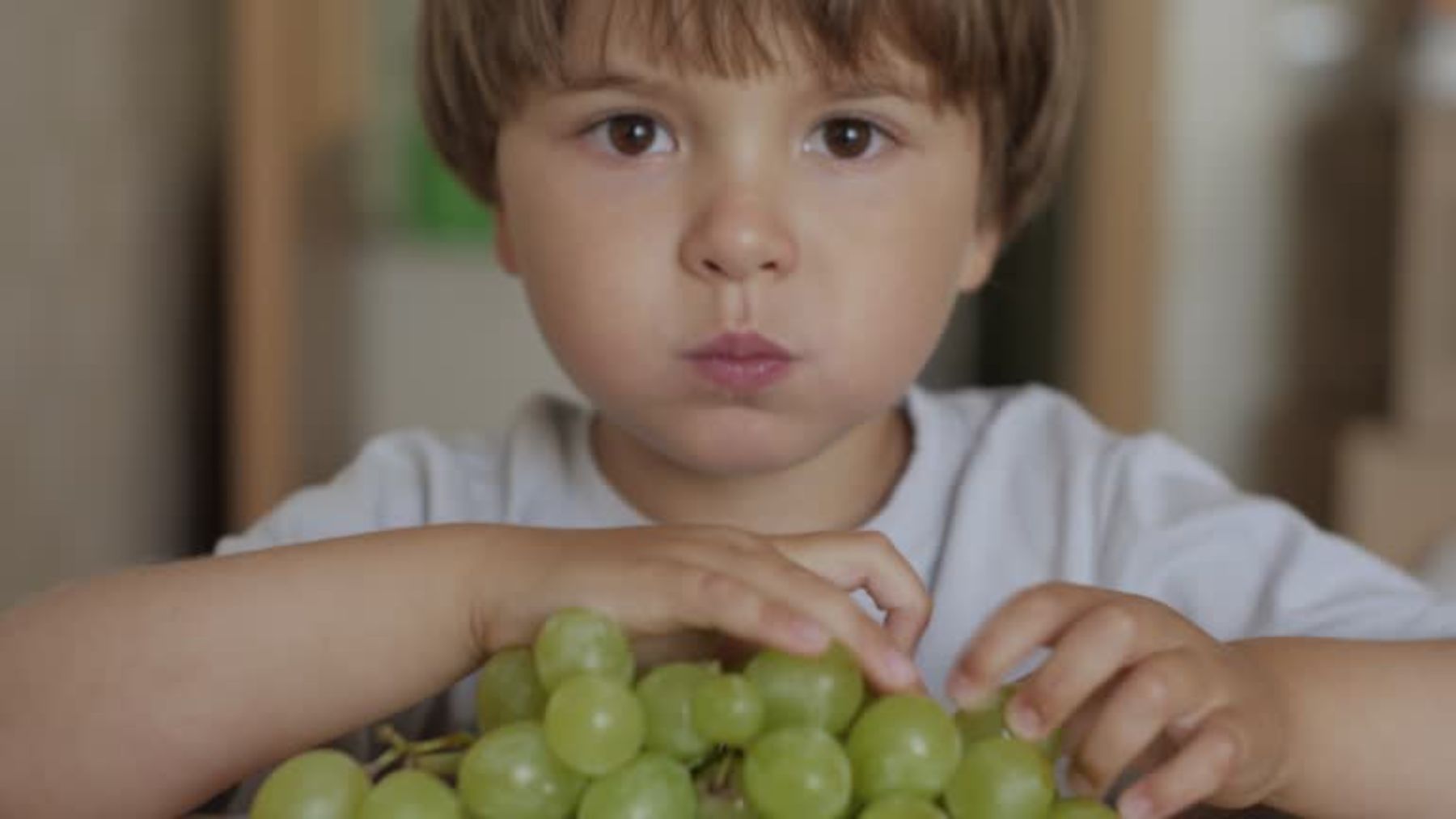 Niño comiendo uvas.