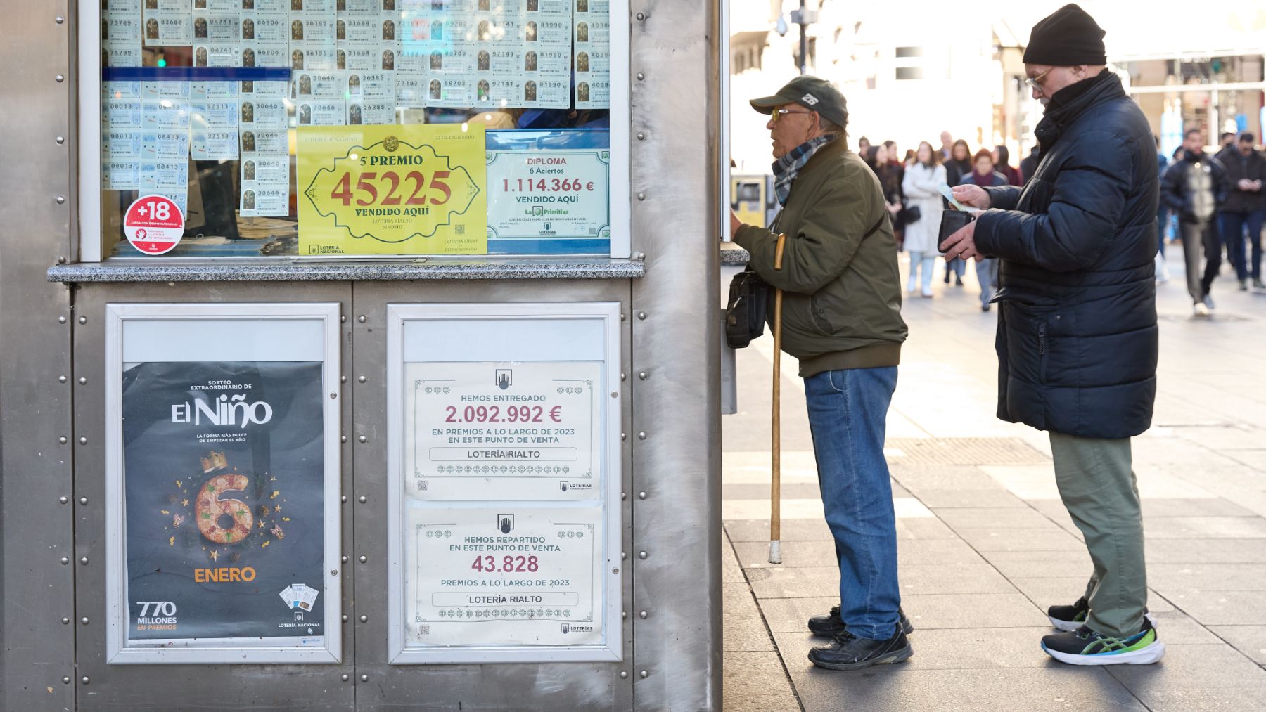 Dos personas hace cola para comprar un décimo de lotería. (EP)