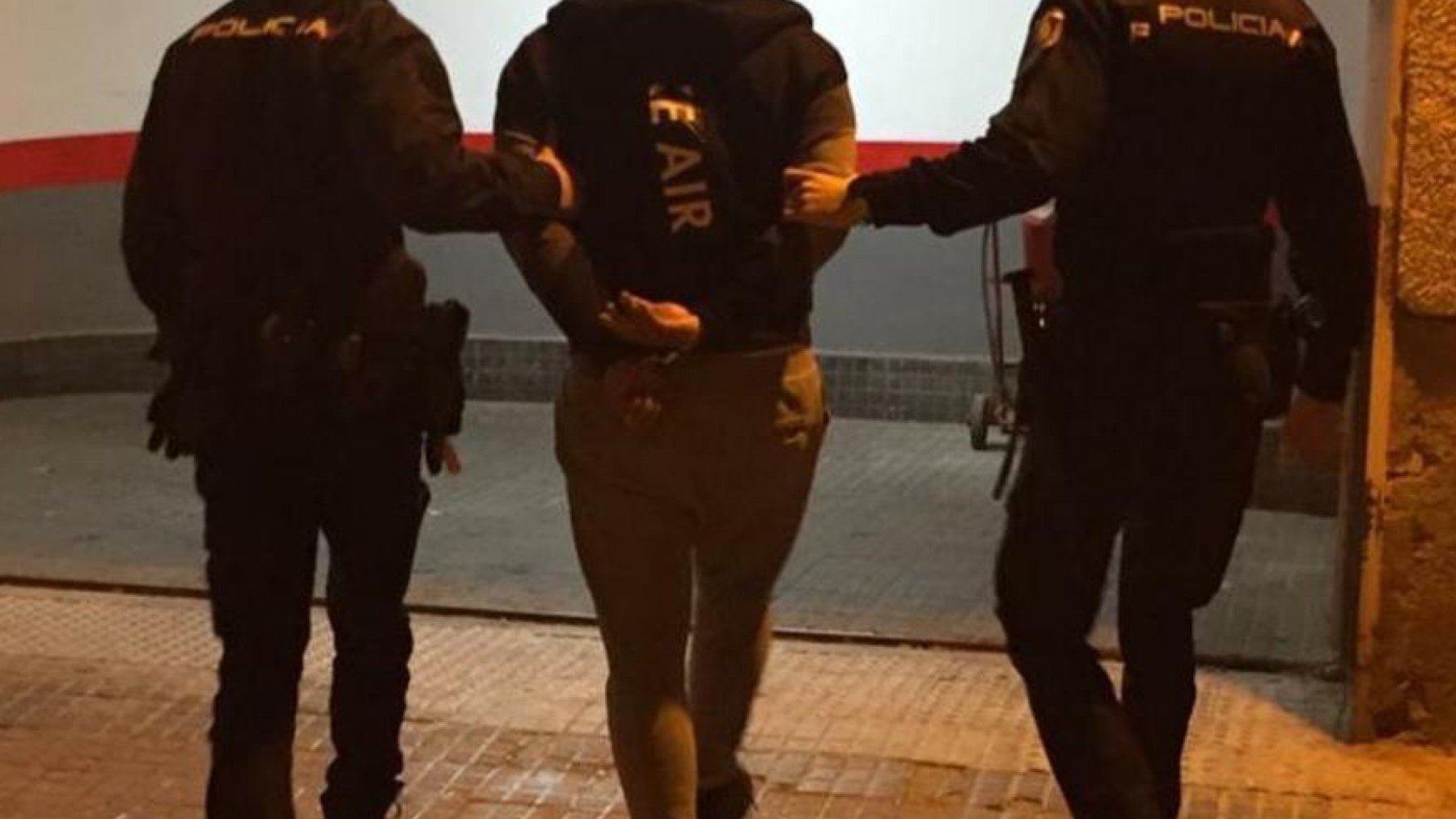 Una pareja de policías de Seguridad Ciudadana conduce a un detenido.