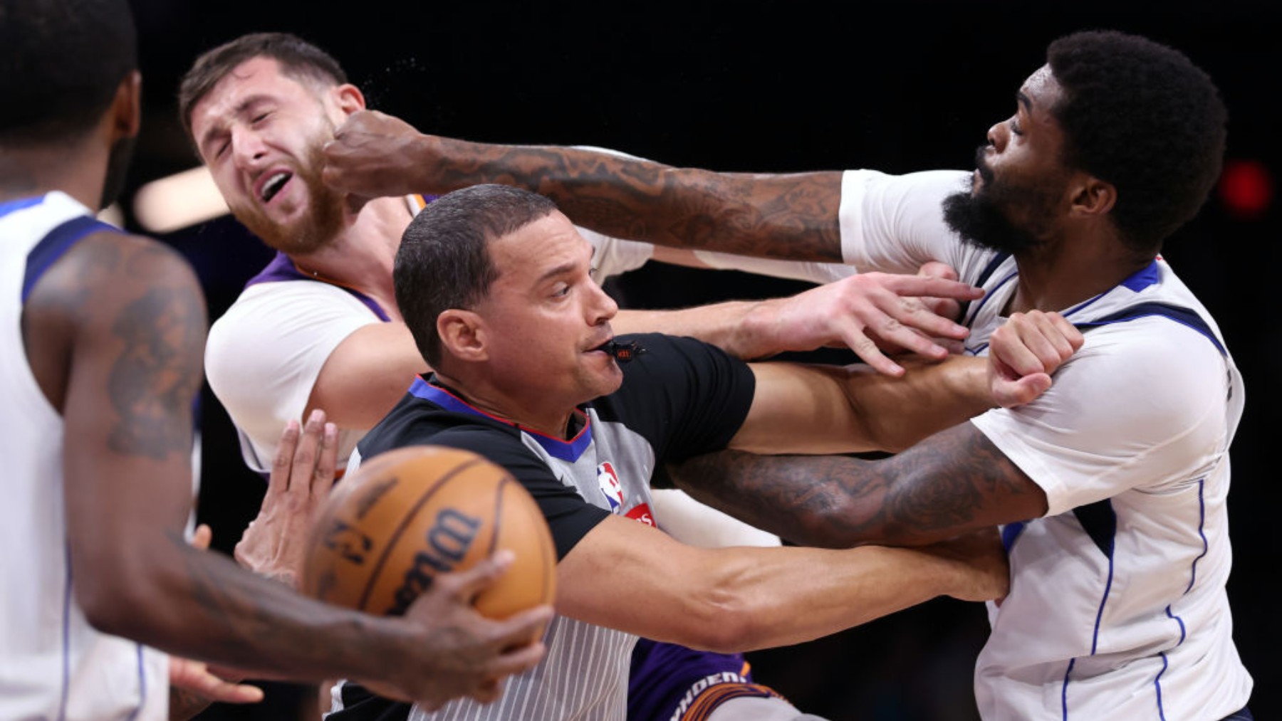 Naji Marshall de los Mavericks golpea a Jusuf Nurkic de los Suns. (Getty)