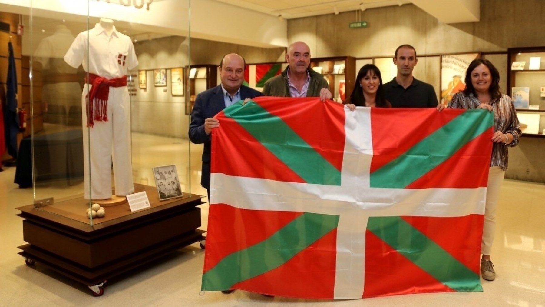 Miembros de la Federación Vasca de pelota sostienen una Ikurriña. (EP)