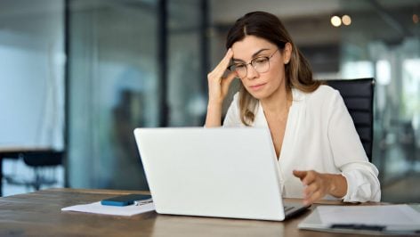 Mujer preocupada mirando su portátil.