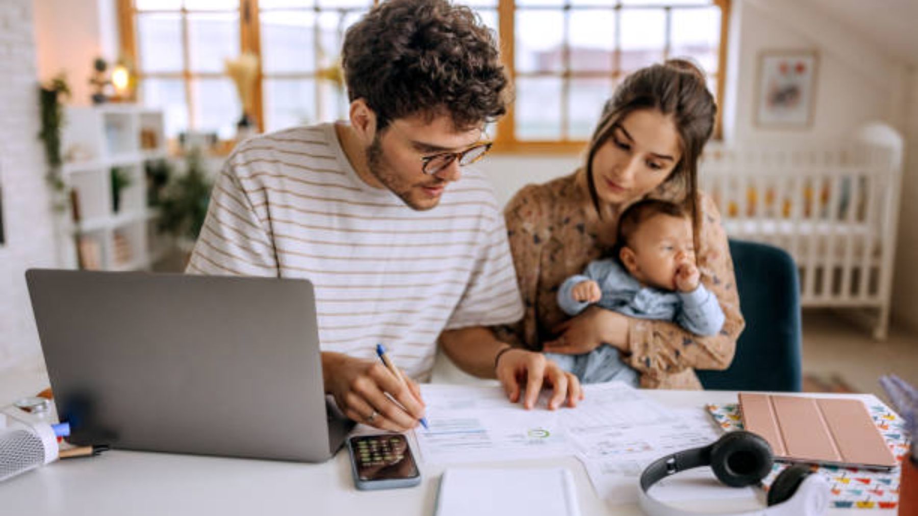 Familia con un bebé observa documentos.