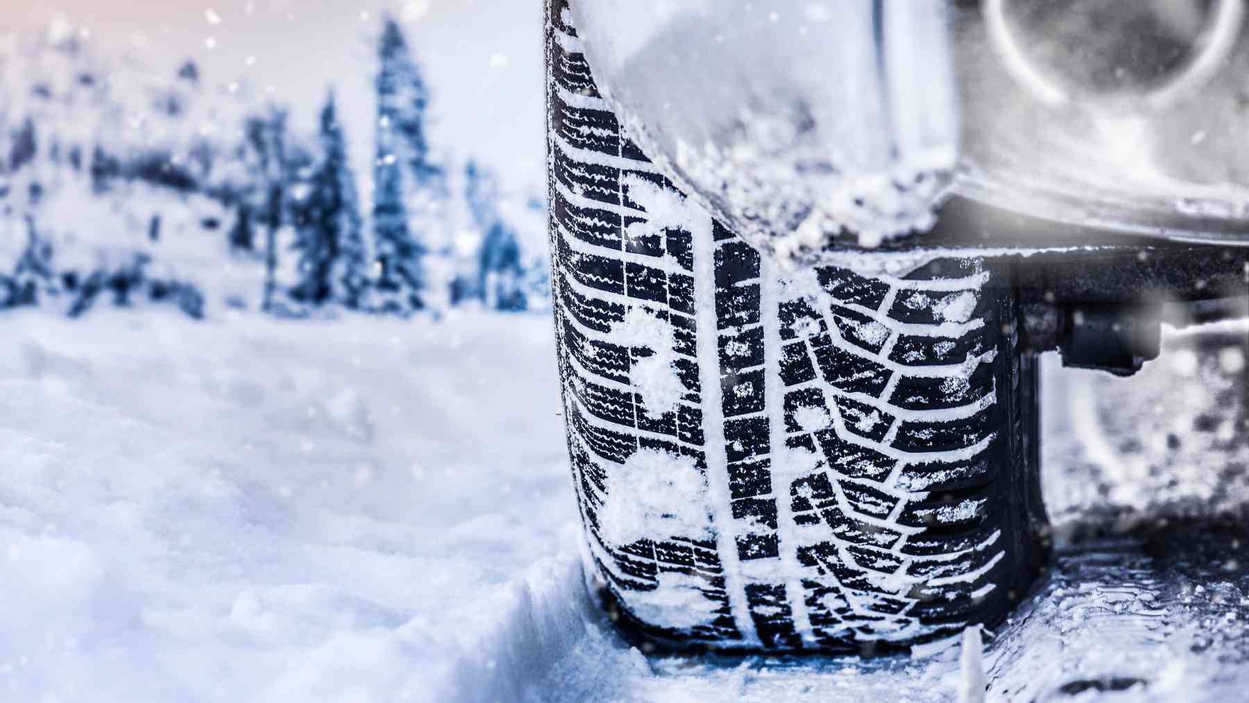 Un vehículo circulando por una carretera nevada.