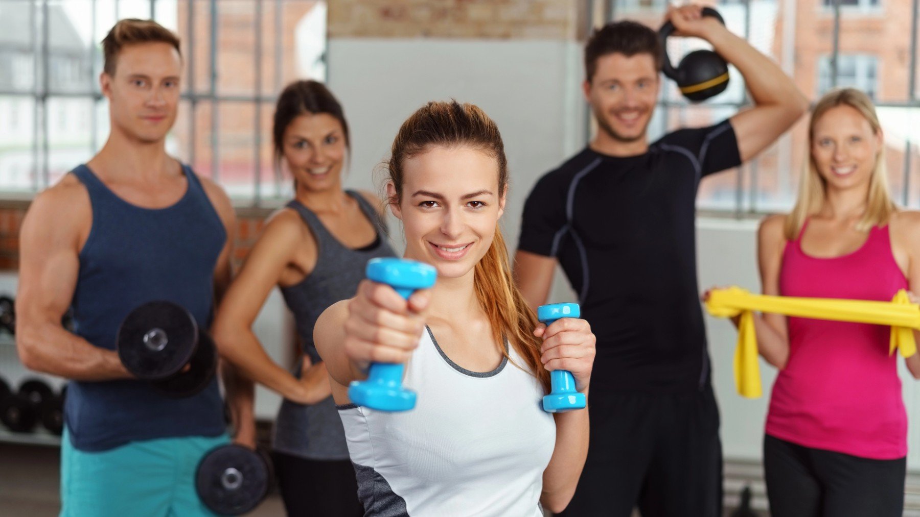 Chicos y chicas haciendo deporte en un gimnasio.