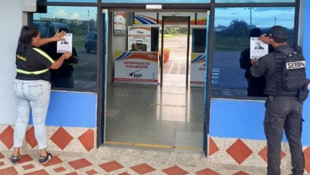 Miembros del SEBIn colocando carteles de Edmundo González con el lema 'Se busca'.