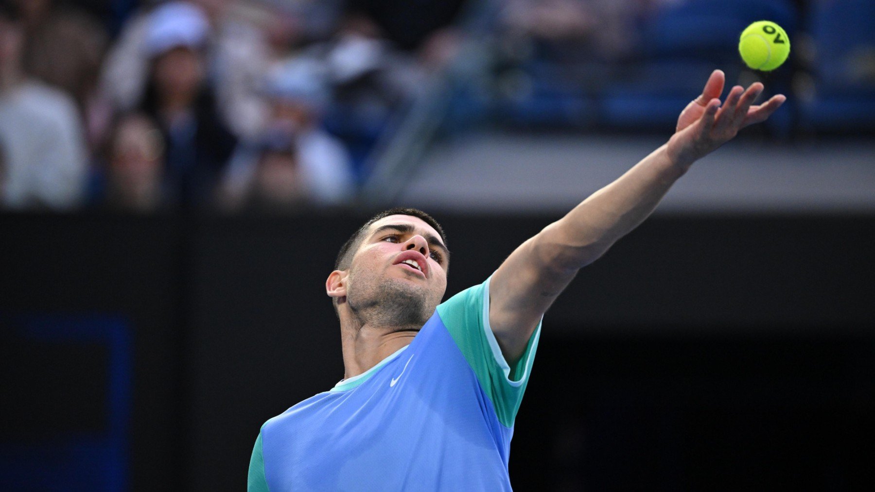 Alcaraz saca durante un partido de exhibición previo al Open de Australia. (EFE)