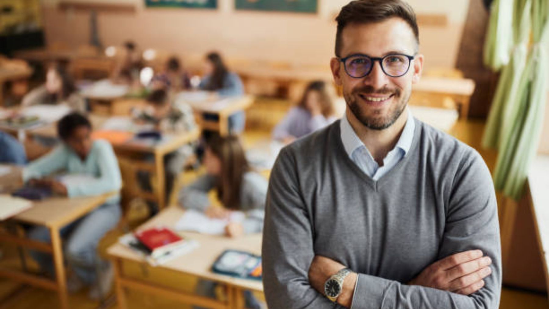 Profesor con sus alumnos de fondo.