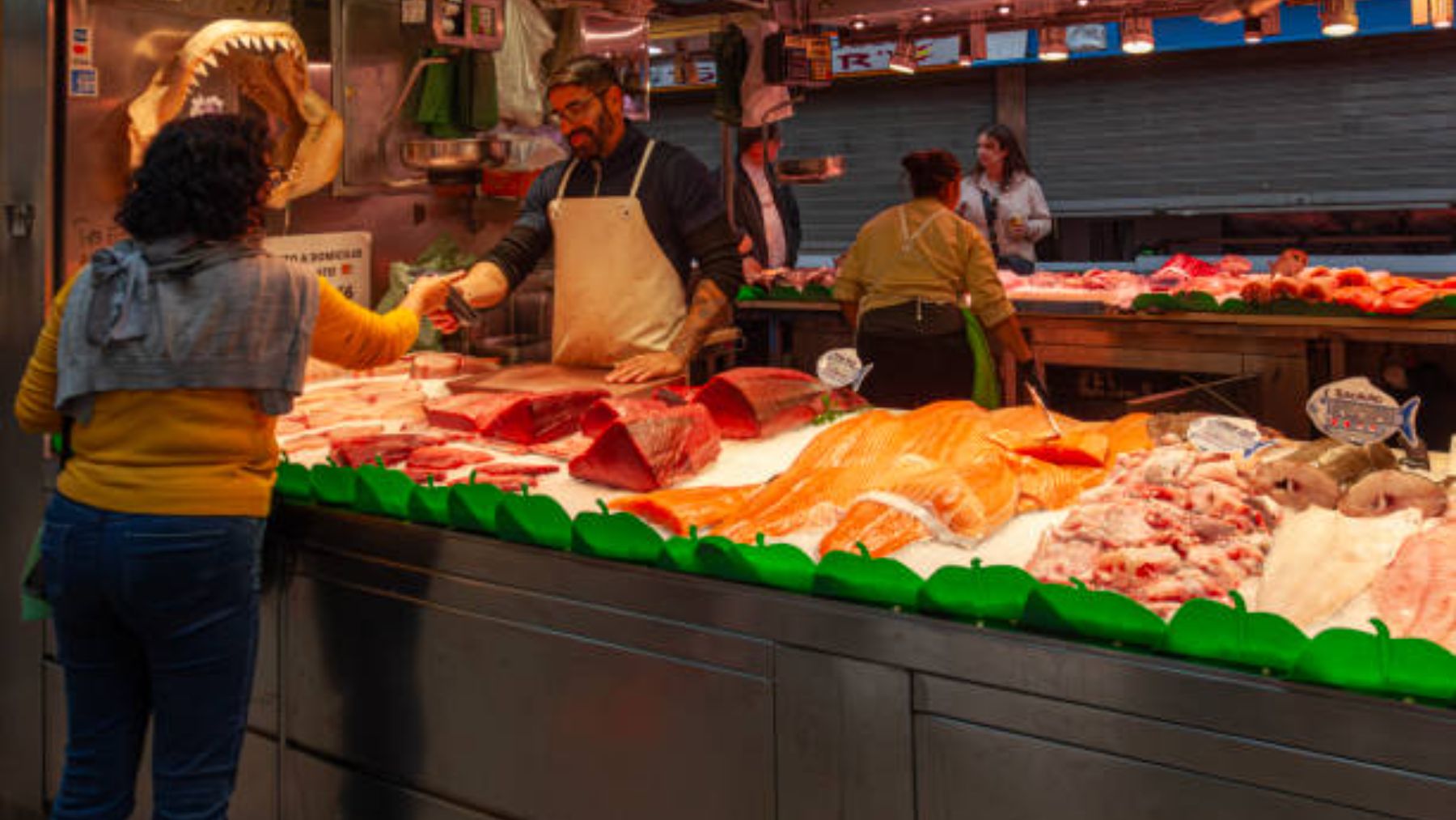 Clienta pagando su compra en una pescadería.