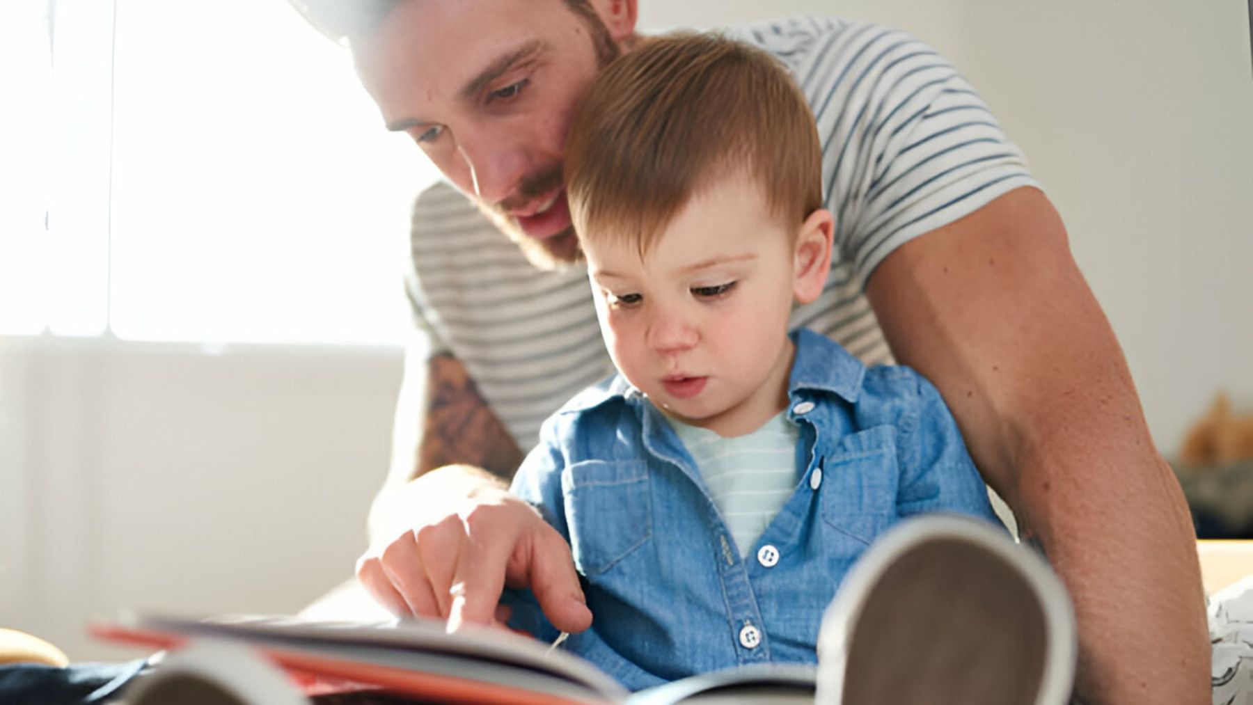 Padre leyendo con su hijo pequeño.