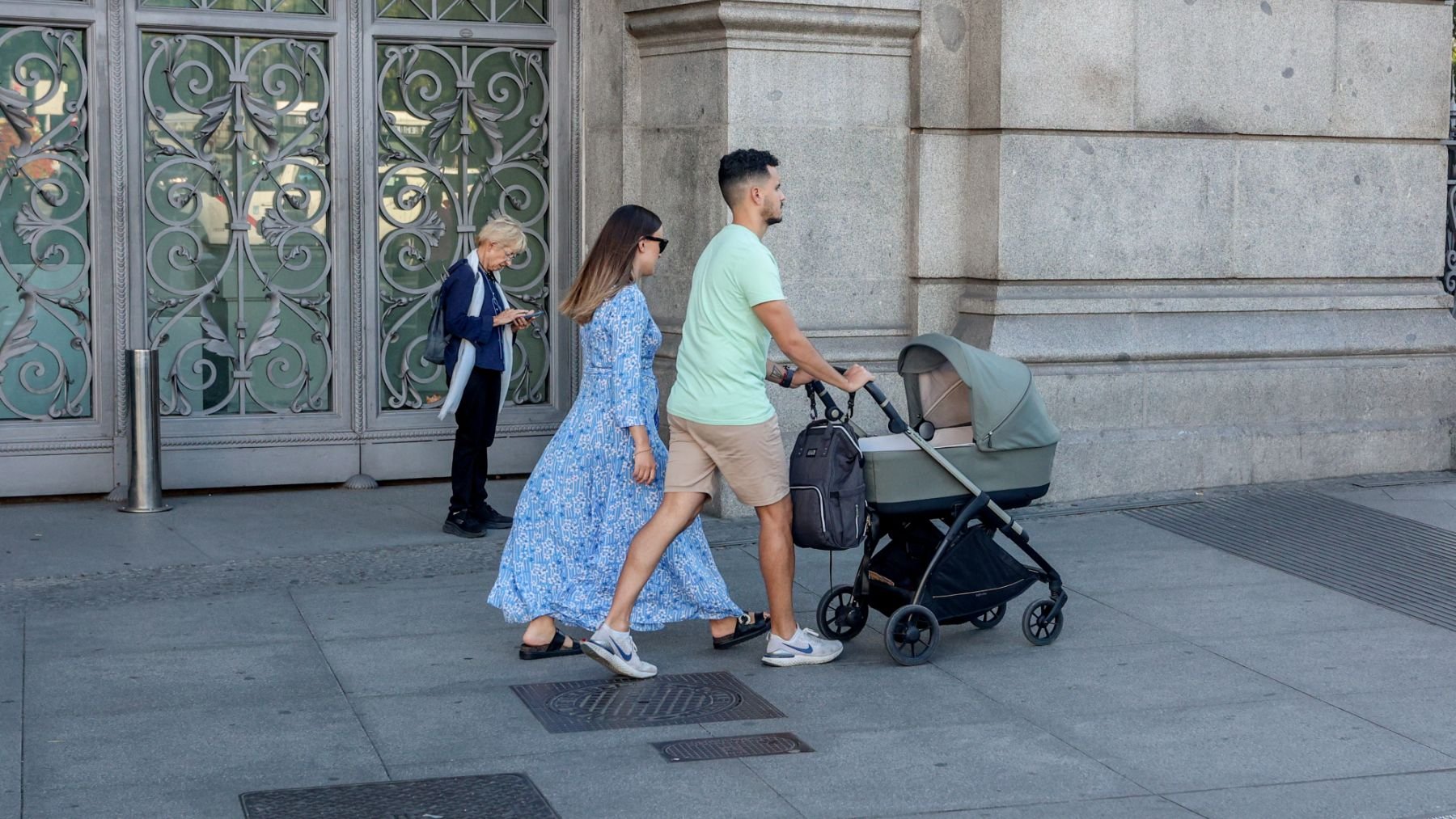 Dos personas pasean con un carrito de bebé. (EP)