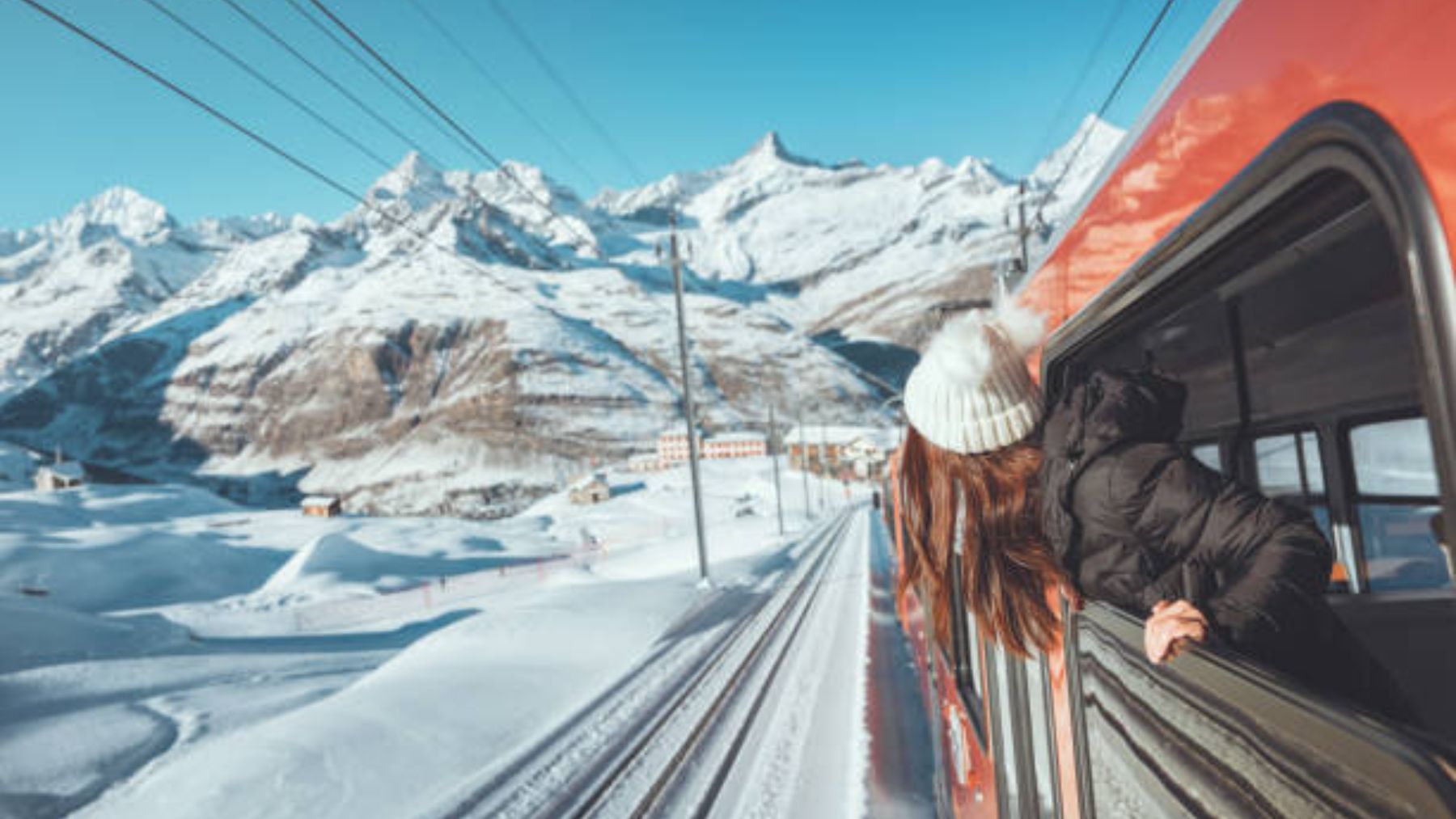 Mujer asomada en un tren frente a un paisaje de nieve.