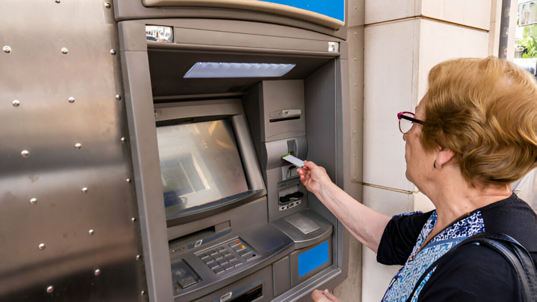 Mujer sacando dinero de un cajero.