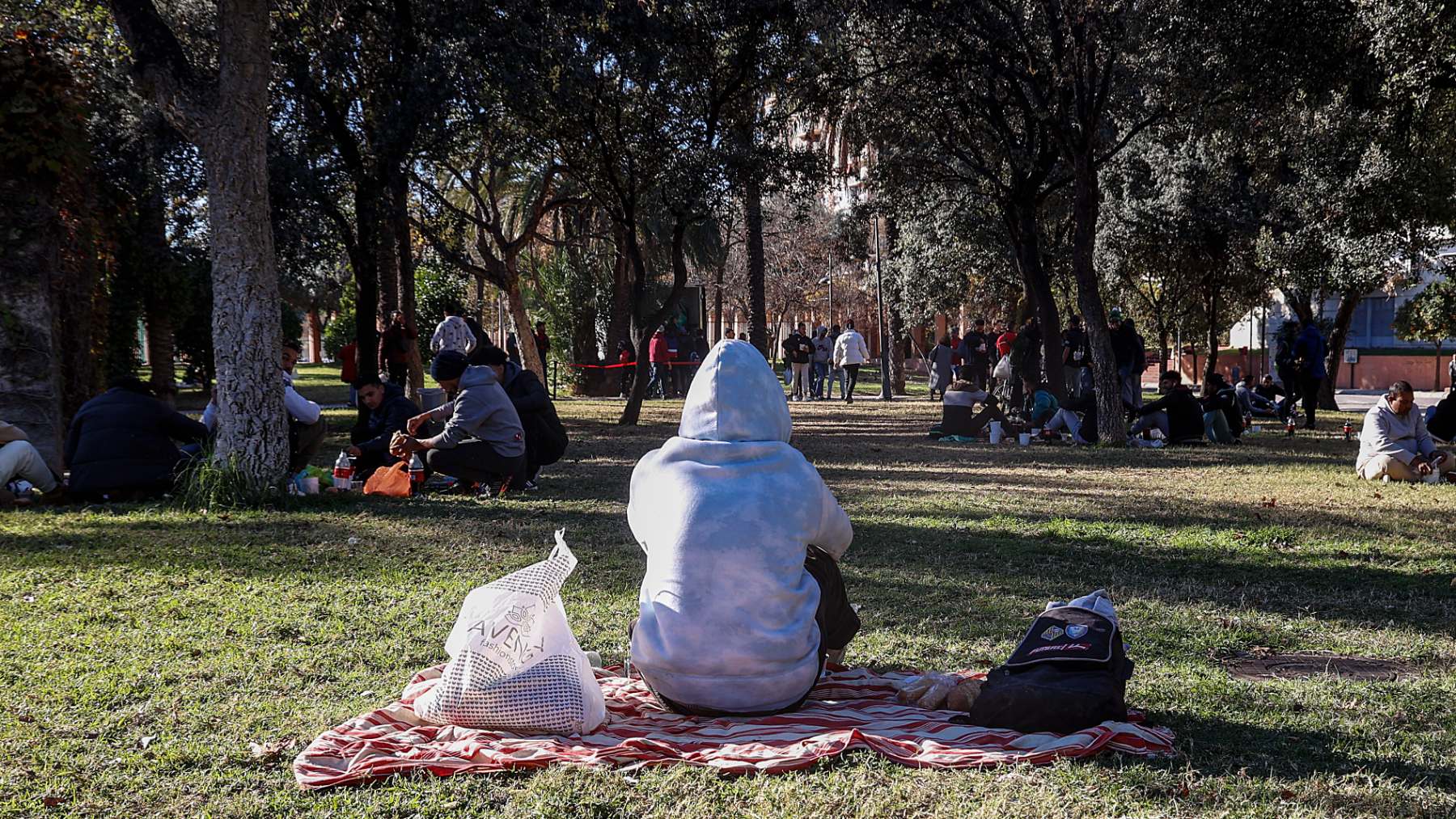 Varias personas comen durante un reparto de alimentos. (EP)