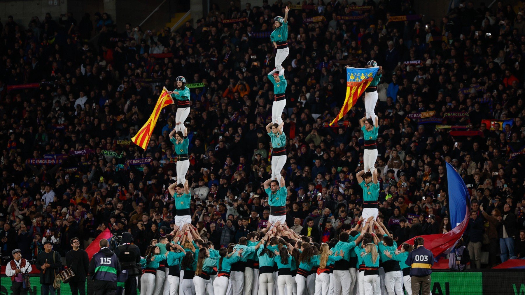 Un grupo de castellers desplega la señera de Valencia. (EFE)