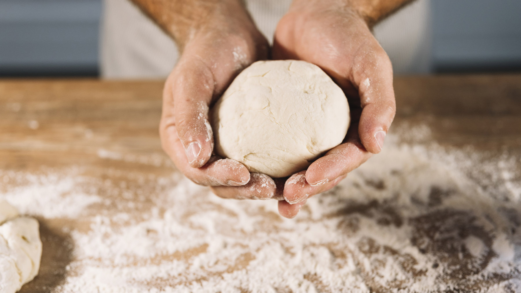 Persona haciendo una masa de pizza. Foto: Freepik.