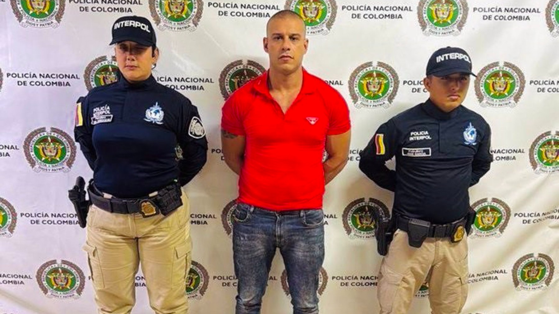 Cristian Lacoma, el detenido, en Colombia junto a dos agentes de la Interpol.