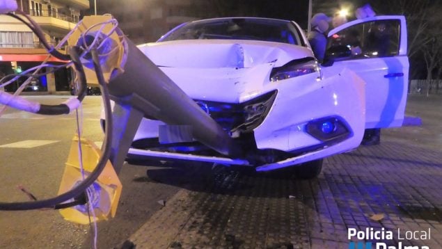 Coche accidentado en la calle Manacor con el semáforo empotrado en el parachoques. -