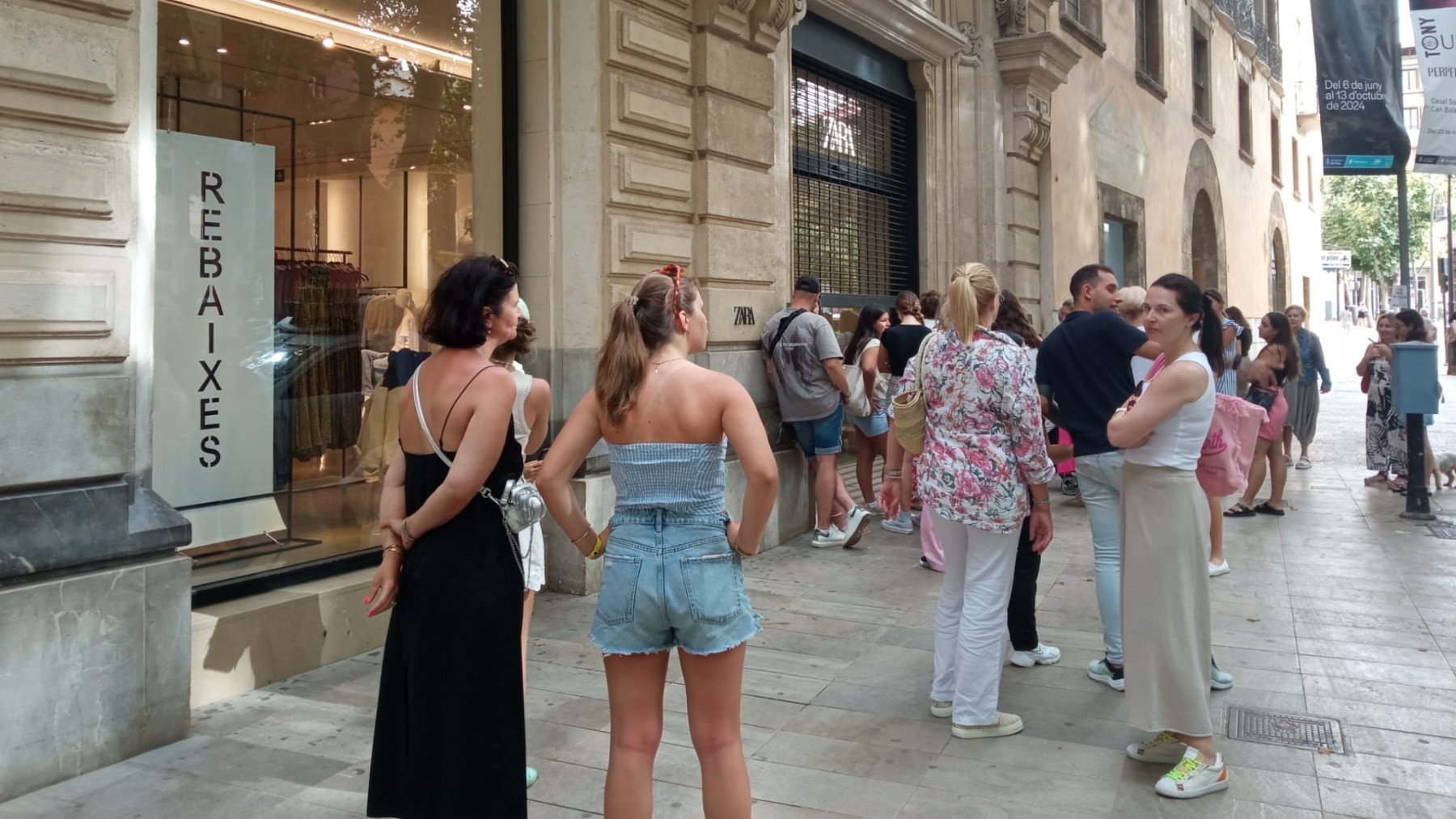 Varias personas esperan en la puerta de una tienda. (EP)