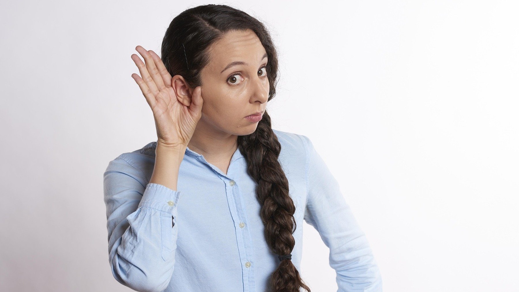 Mujer tocándose la oreja.