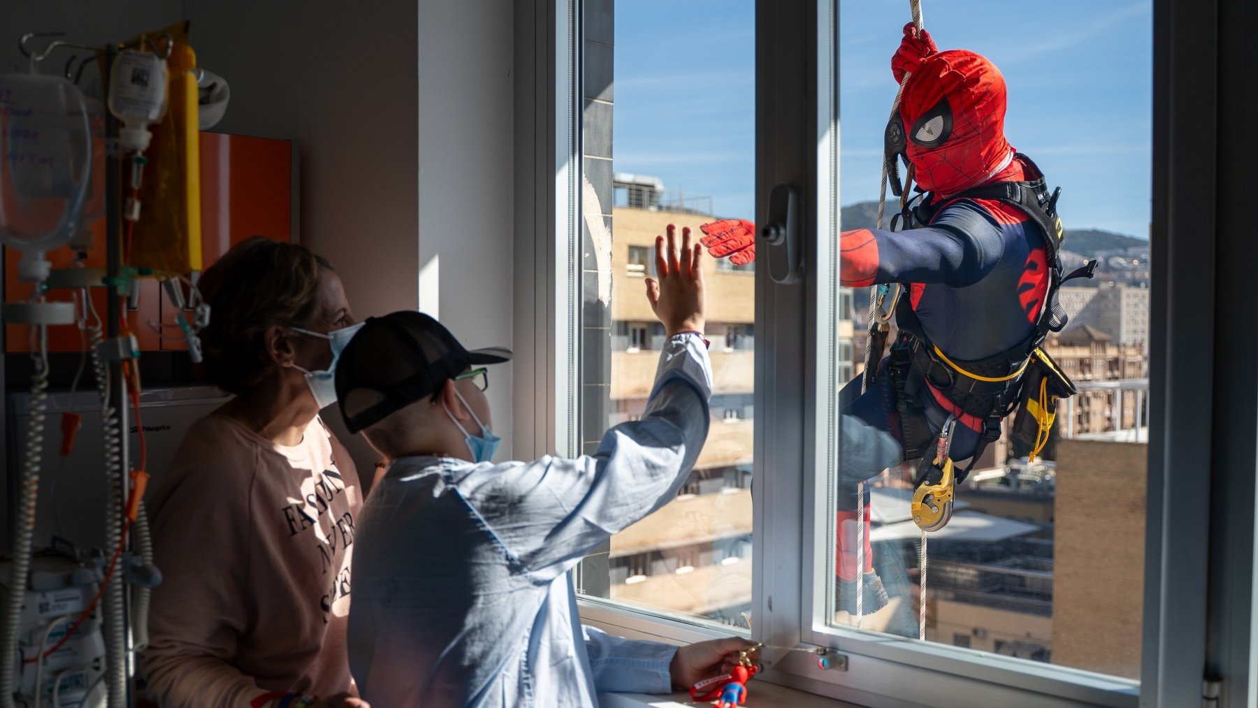 Un niño hospitalizado en el Materno Infantil de Granada saluda a Spiderman. (Junta)