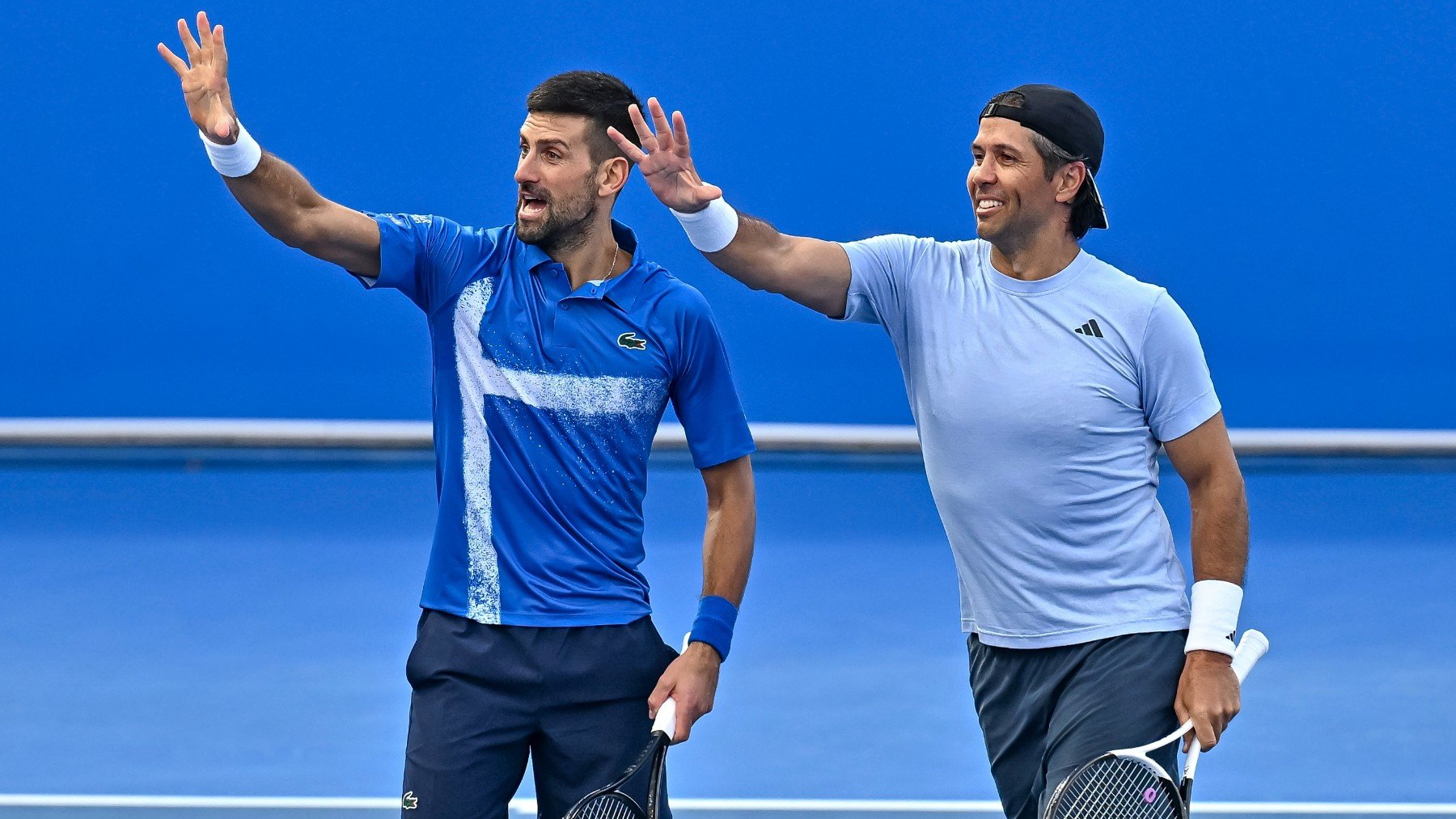 Novak Djokovic y Fernando Verdasco hacen un gesto al banquillo del madrileño. (EFE)