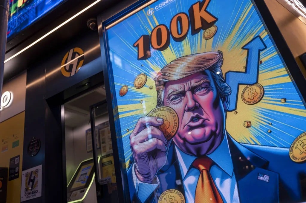 Un dibujo del presidente estadounidense, Donald Trump con Bitcoin en la mano en la fachada de una tienda de Coinhero, en Hong Kong. Fuente: Bloomberg