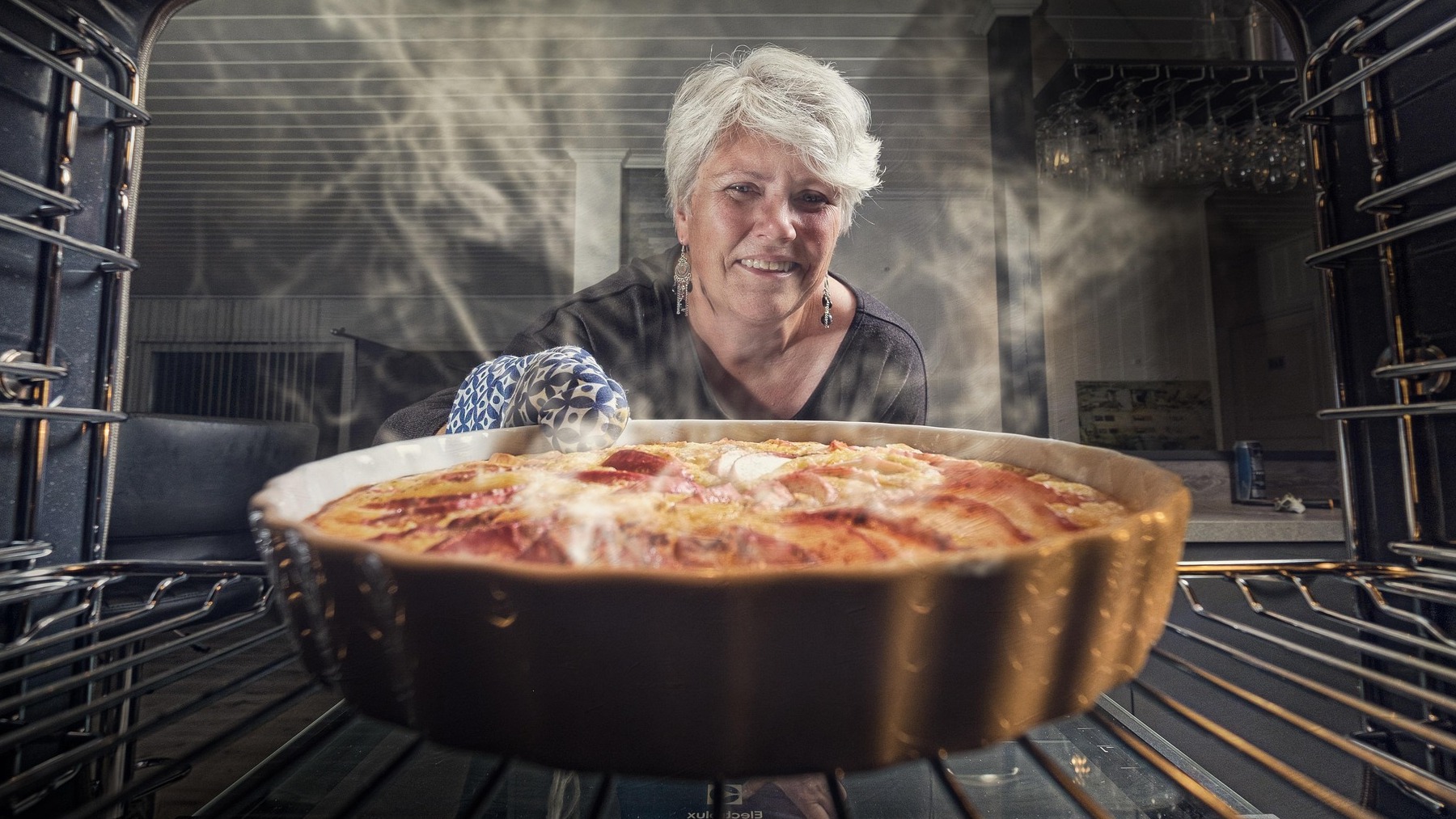 Mujer sacando una tarta del horno.