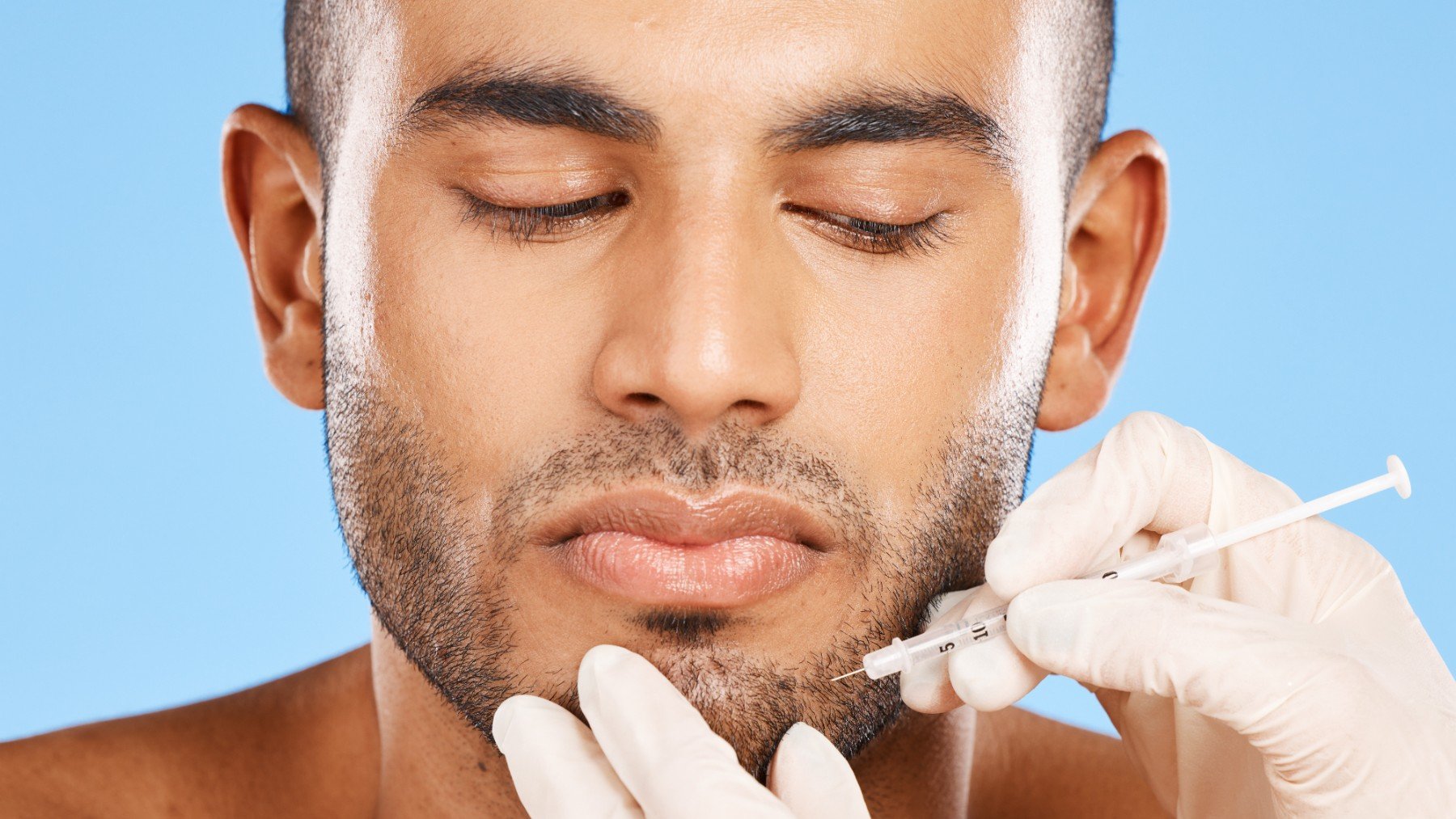 Un doctor prepara a un hombre para una cirugía estética facial.