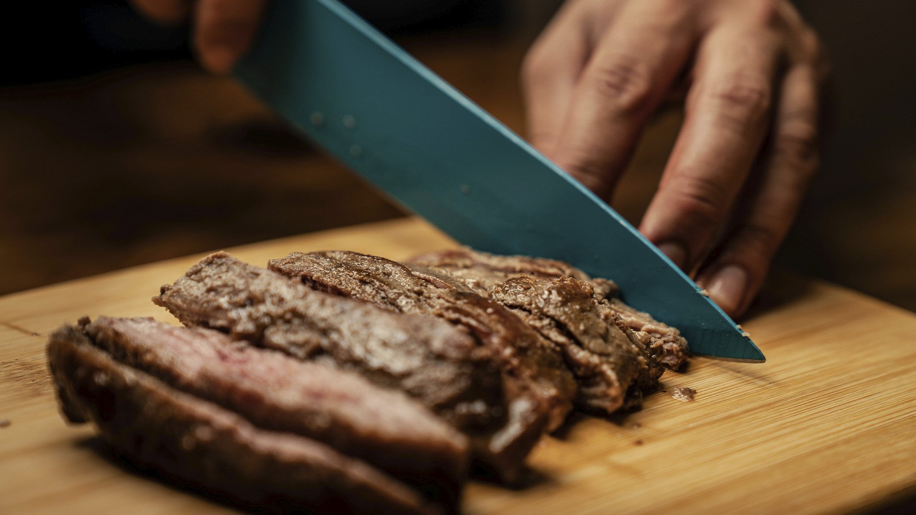 Cocinero cortando carne. Foto: Pexels.