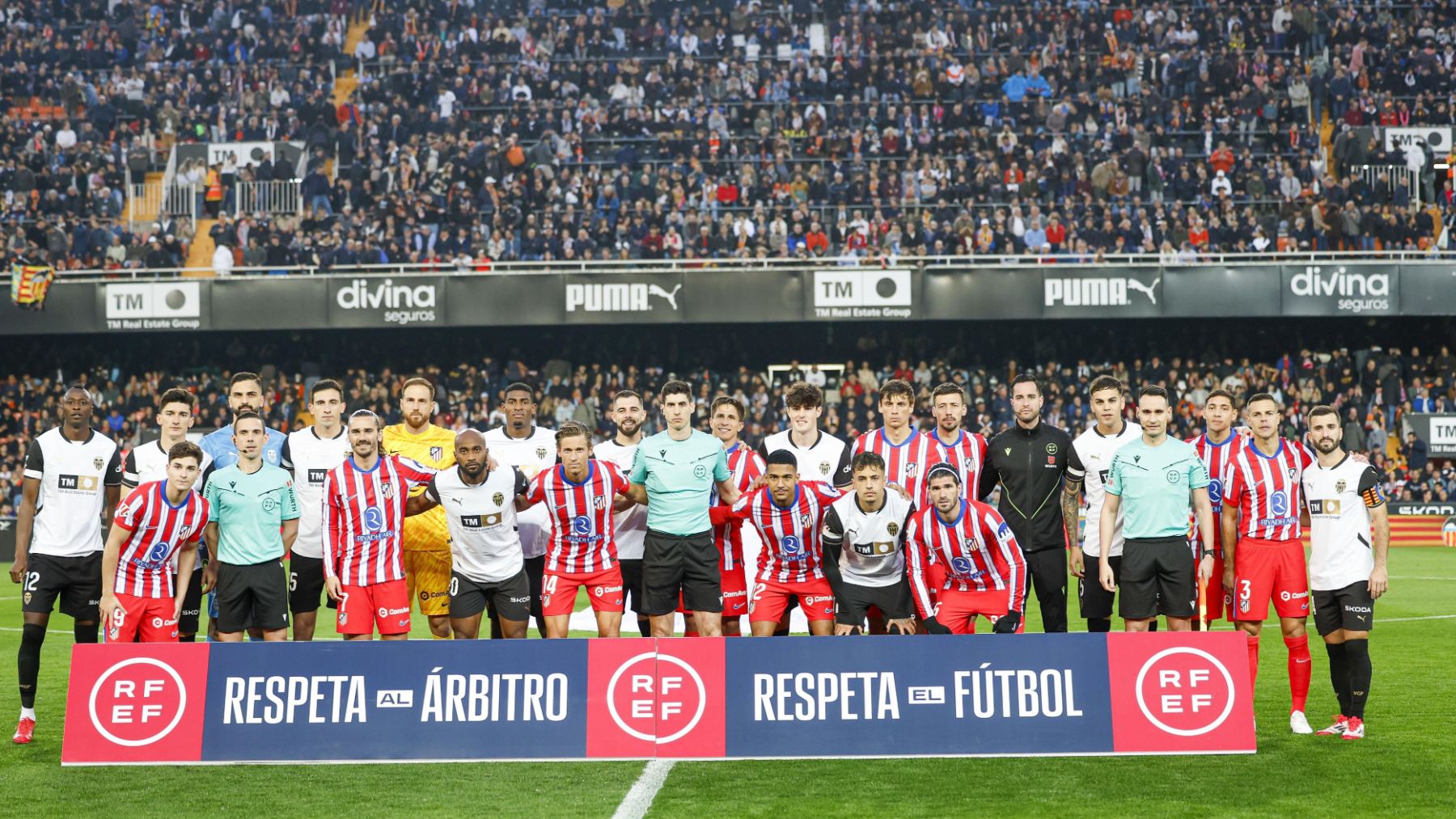 Atlético, Valencia y equipo arbitral posando antes del partido.