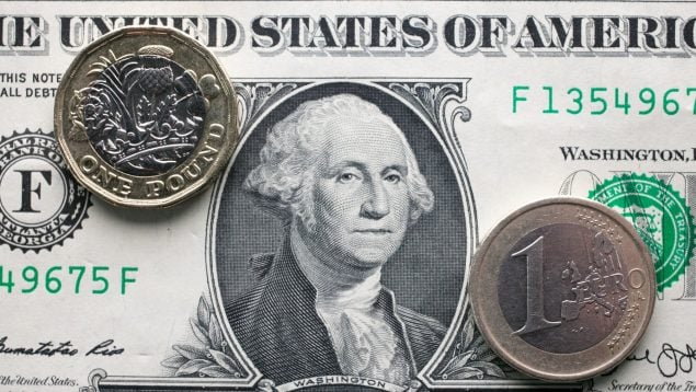 Un euro y una libra sobre el billete verde.