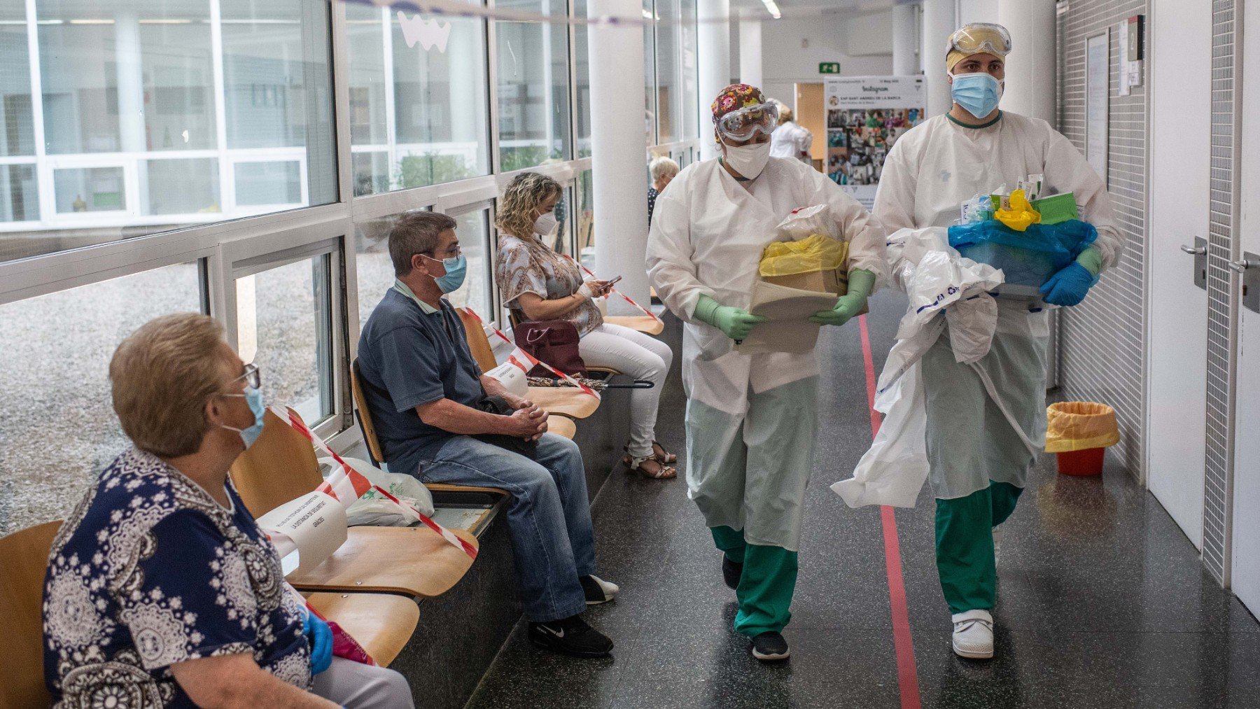 Varios sanitarios con Epis en un pasillo de hospital.