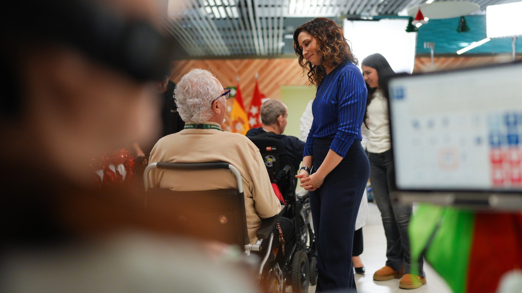 La presidenta de la Comunidad de Madrid, Isabel Díaz Ayuso, conversa con una persona que padece ELA.