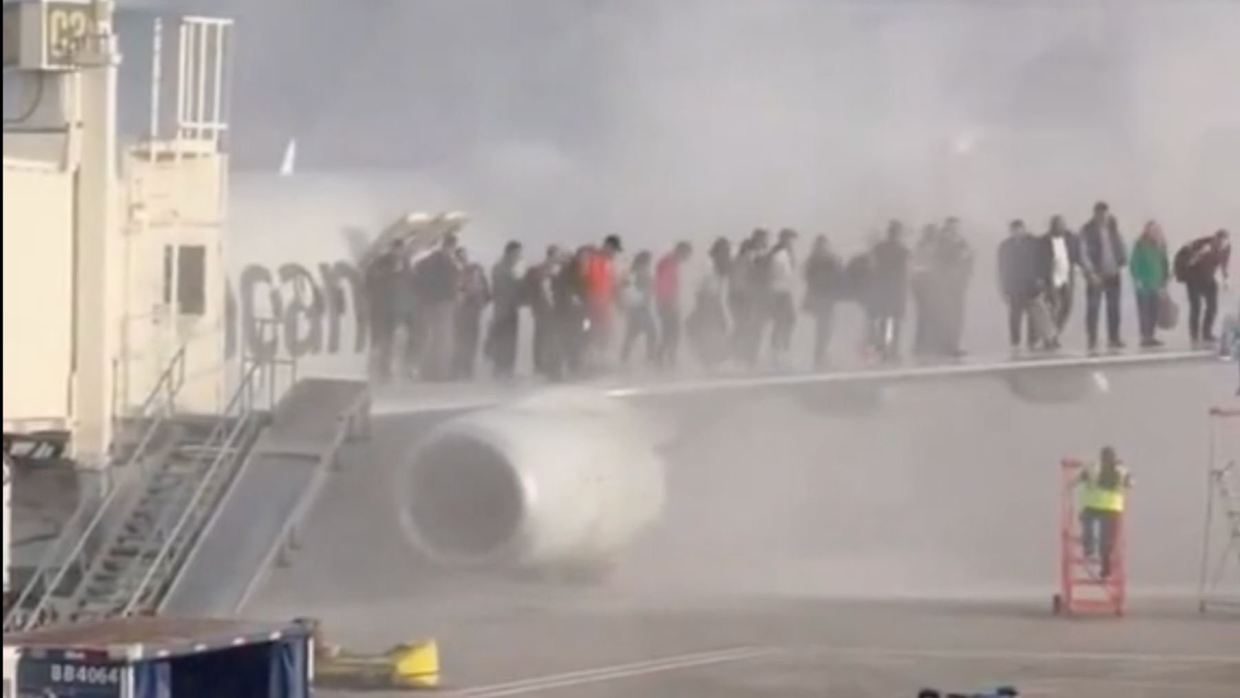 Los pasajeros de un avión incendiado de American Airlines salen por un ala.