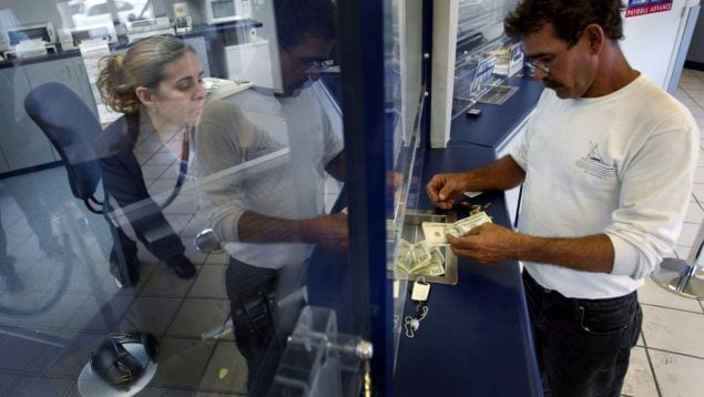 Ramon Cruz envía dinero en un sucursal de Western Union desde Miami a familiares en Cuba. Getty Images