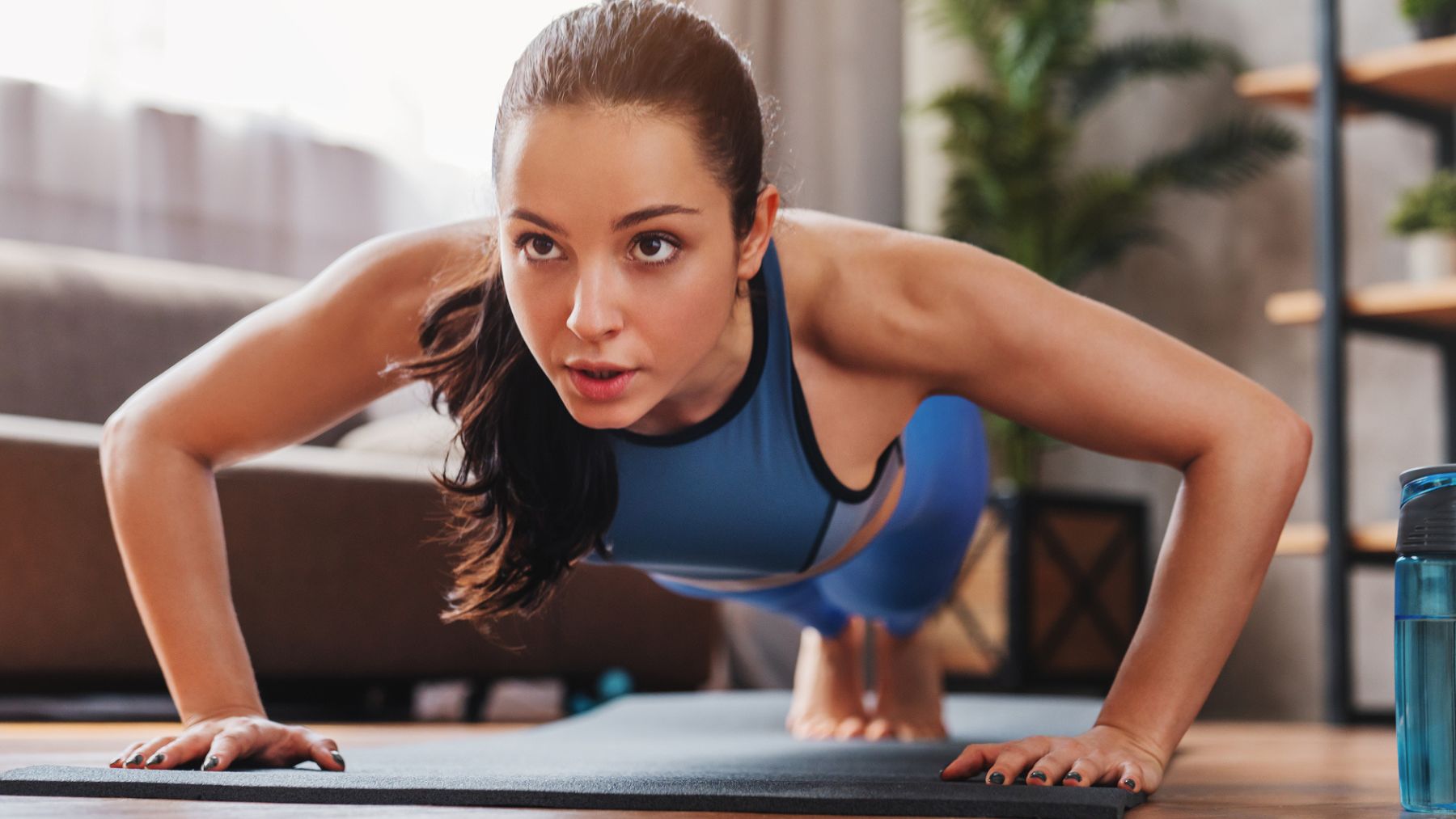 Una mujer entrenando en casa.