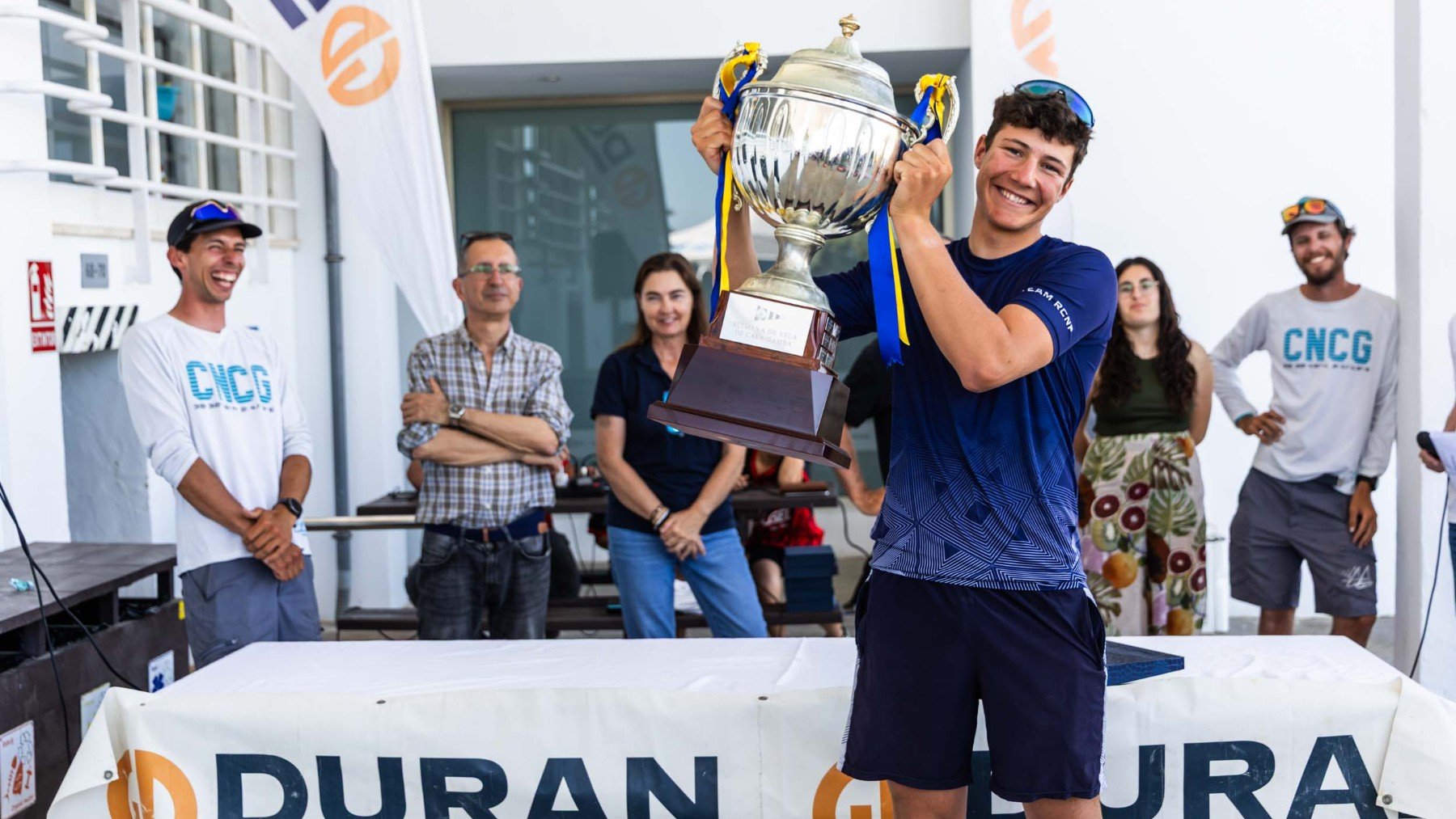 Tim Lubat levanta la copa de Campeón de la Setmana de la Vela.